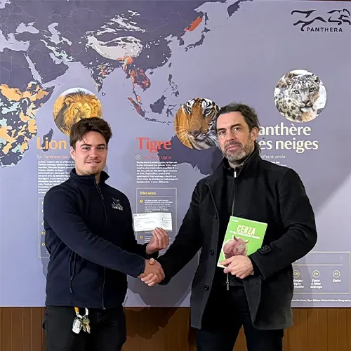 Hugo Jardin President Lumigny Safari Reserve and Grégory Breton Director Panthera shaking hands in front of a presentation panel on big felines.
